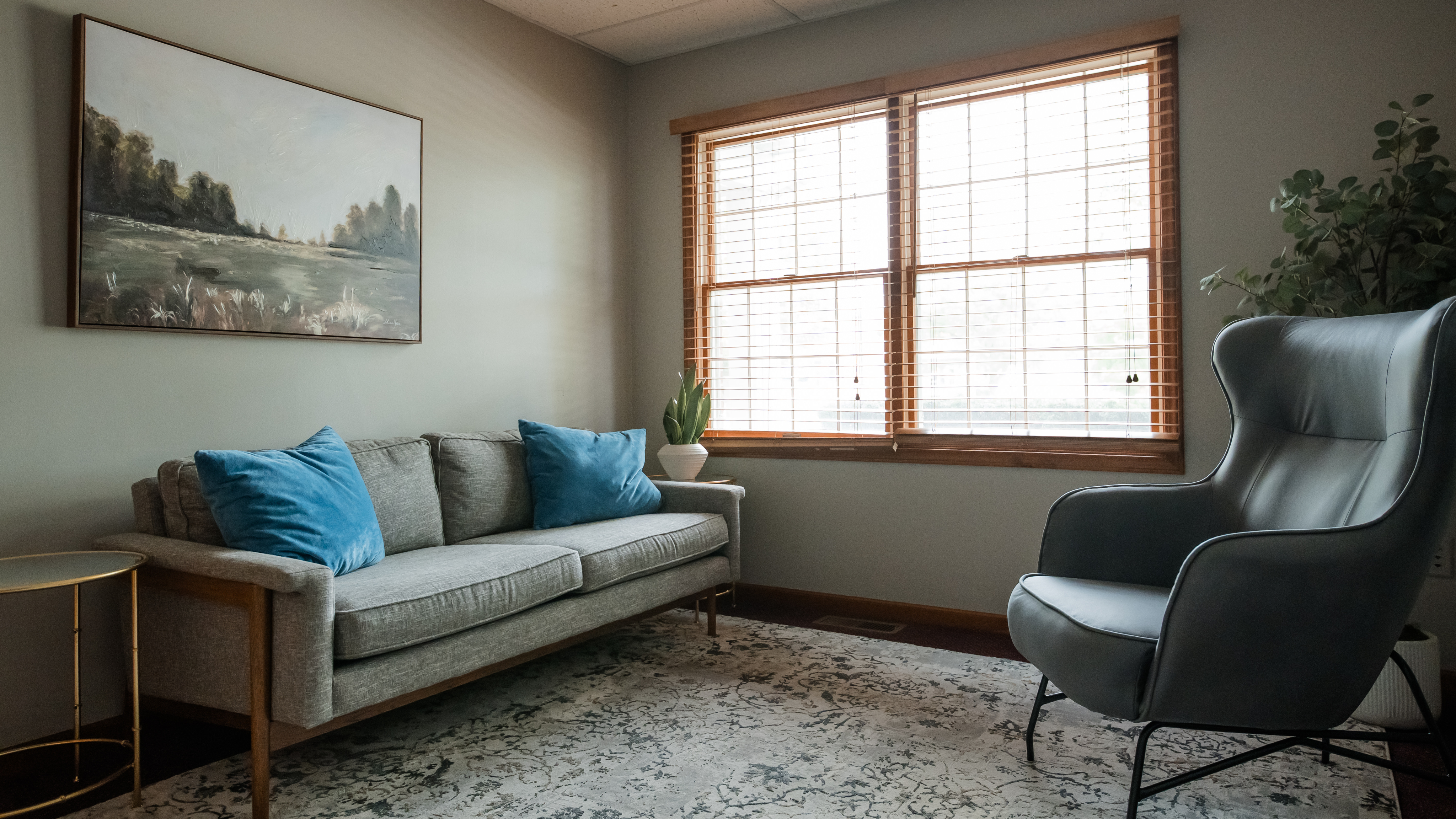 Comfortable couch and chair lit by large window